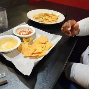 Queso and salsa with Diablo pasta in the background