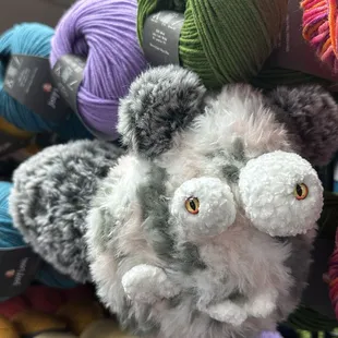 Fluffy crochet amigurumi monster in pink and gray. It has silly teeth and bulgy eyes!