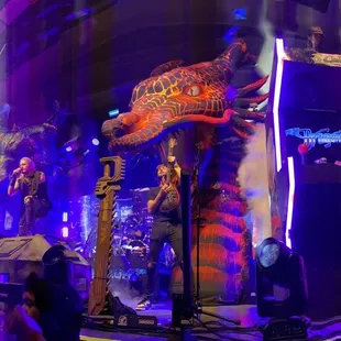 a man on a stage with a giant statue in the background