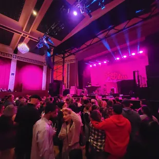 a crowd of people in a large auditorium