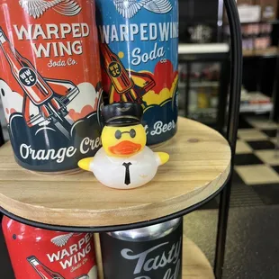 three cans of orange soda and a rubber duck