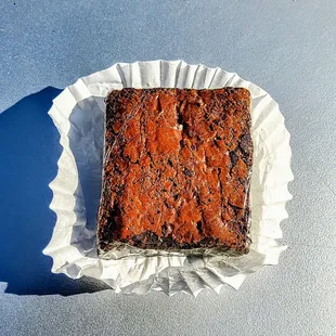 a chocolate brownie on a white paper plate