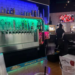 a view of a bar with a man sitting at the bar