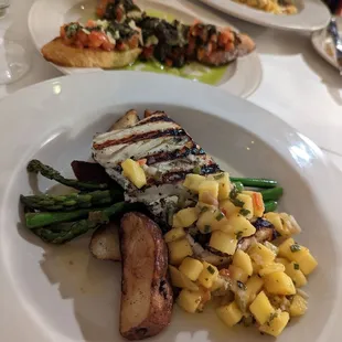 Grilled halibut covered in mango salsa, with grilled asparagus and potatoes