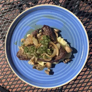 Wagyu steak with mashed Yukon gold potatoes, mushrooms, caramelized onions, and chimichurri sauce