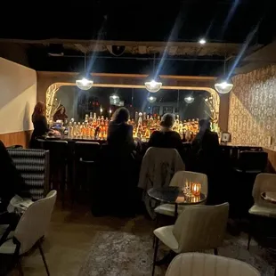 people sitting at tables in a dimly lit bar