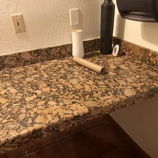 a bathroom counter with a roll of toilet paper