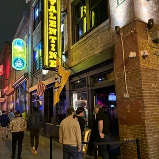 people walking down a city street at night