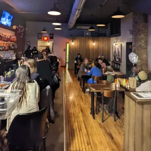 a crowded restaurant with people sitting at tables