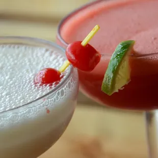two cocktails with garnishes