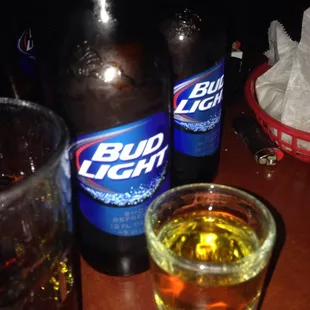 two bottles of bud light and a glass of beer