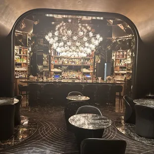 a dimly lit bar with a chandelier