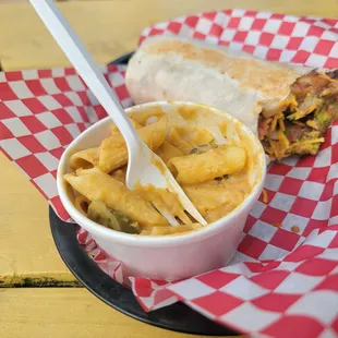 a burrito and a bowl of macaroni and cheese