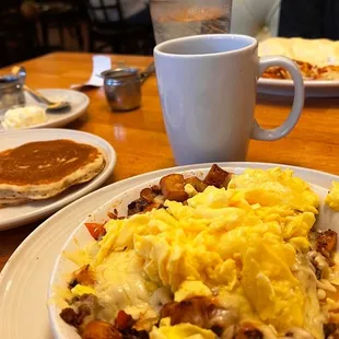 a breakfast of eggs, hash browns and pancakes