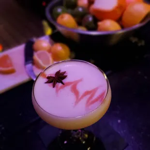 a cocktail with a star anise garnish