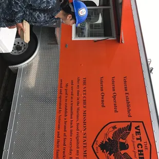 a man putting a blue hat on a food truck