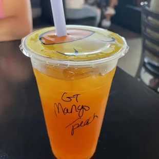 Boba green tea with mango flavoring and peach bubbles