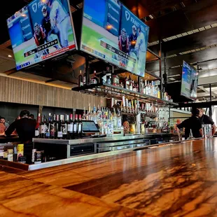 people at a bar watching televisions