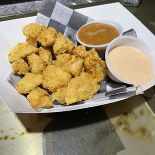 a basket of fried chicken with dipping sauce