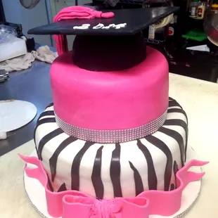 Tiered graduation cake with fondant icing, including the graduation cap.