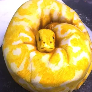 A 7 layered round cake covered in textured fondant and airbrushed and painted to form pattern.