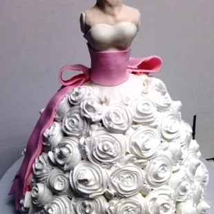 A Dress form cake for a wedding shower. Buttrercreme roses cover the cake with the dress form in rice krispy treats and fondant.