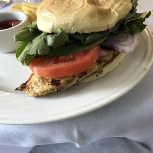 Grilled chicken sandwich with French fries.