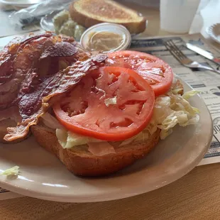 a sandwich with bacon, tomato and lettuce