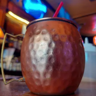 a copper mug with a straw in it