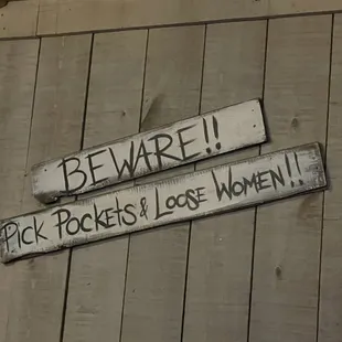 two wooden signs on a wall