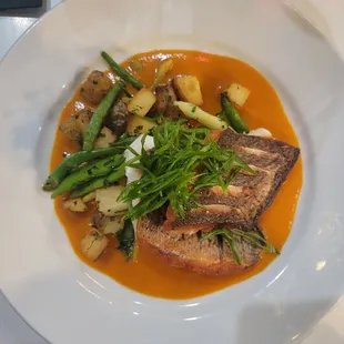 Sea bass special with roasted vegetables in a tomato butter sauce.