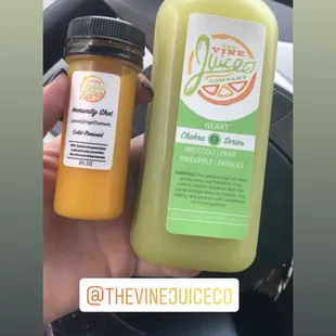 a hand holding a bottle of juice