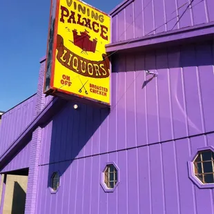 a purple building with a yellow sign