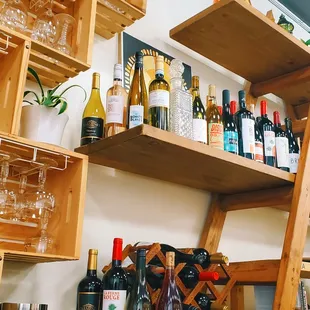 a shelf of wine bottles and glasses