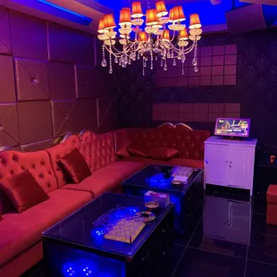 a living room with a red couch and a chandelier