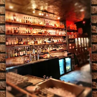 a brick wall with shelves of liquor