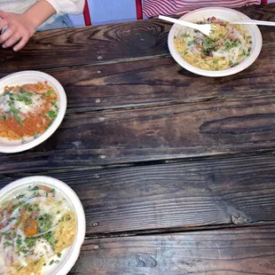 three plates of food on a wooden table