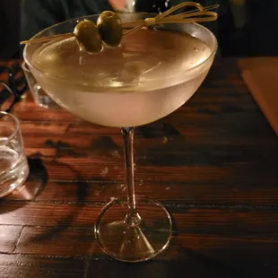a woman sitting at a table with a martini