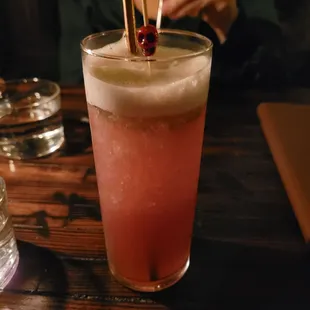 a woman sitting at a table with a drink