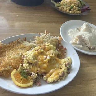 Ham &amp; cheddar scrambled eggs with hash browns with biscuits and gravy on the side. YUM