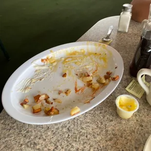 The remnants of my chicken fried steak, eggs and potatoes with half of a waffle.