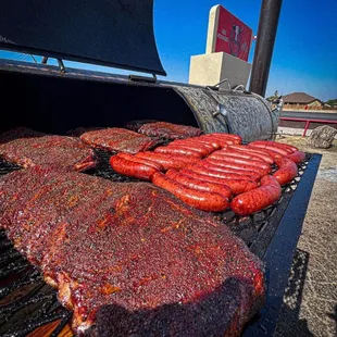 a bbq full of meat and sausages
