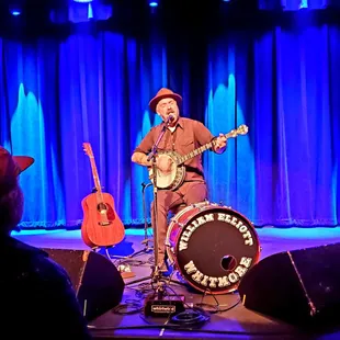 a man playing a banjo on stage