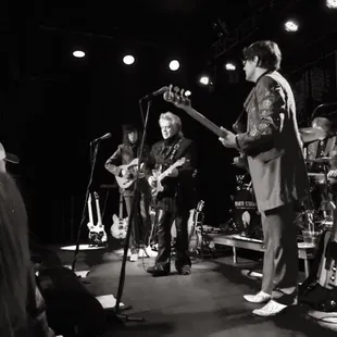 a black and white photo of a band on stage