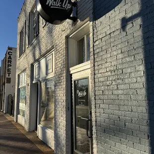 a brick building with a sign that reads walk up