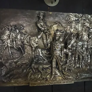 Metal cast of Paul Revere scene near bar