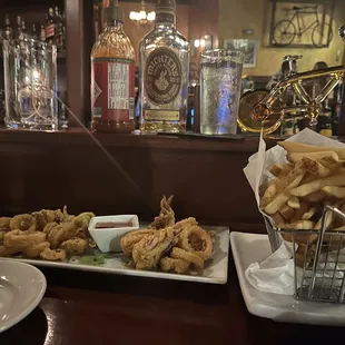 a plate of fried onion rings and a basket of fried onion rings