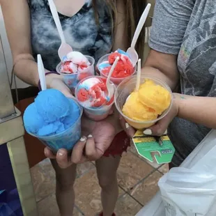three people holding cups of ice cream