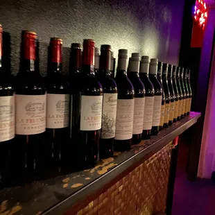 a row of wine bottles on a shelf