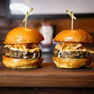 two burgers on a wooden board